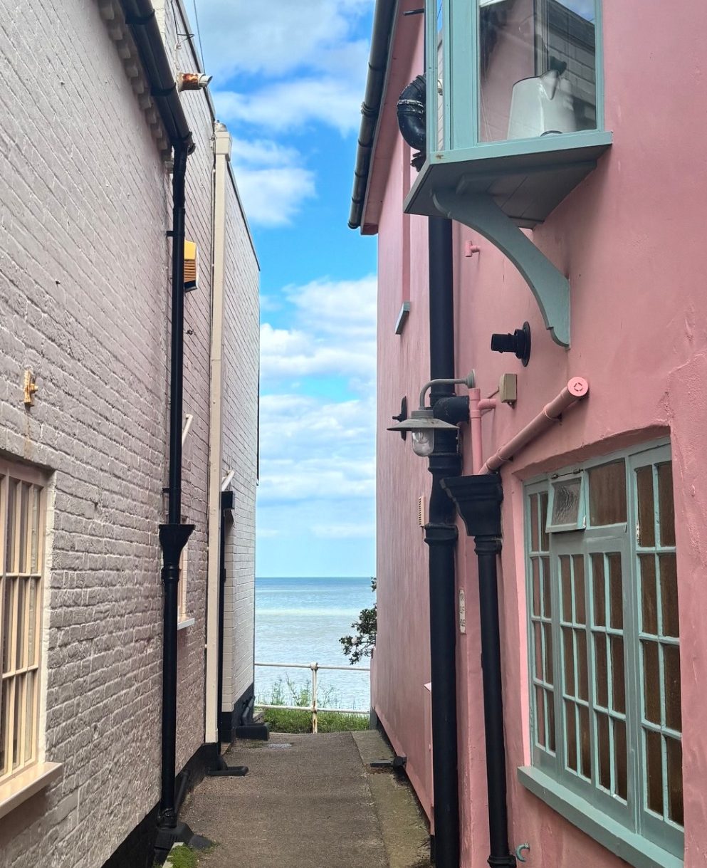 Narrow, old walkway between two very old cottages, leading to the sea.